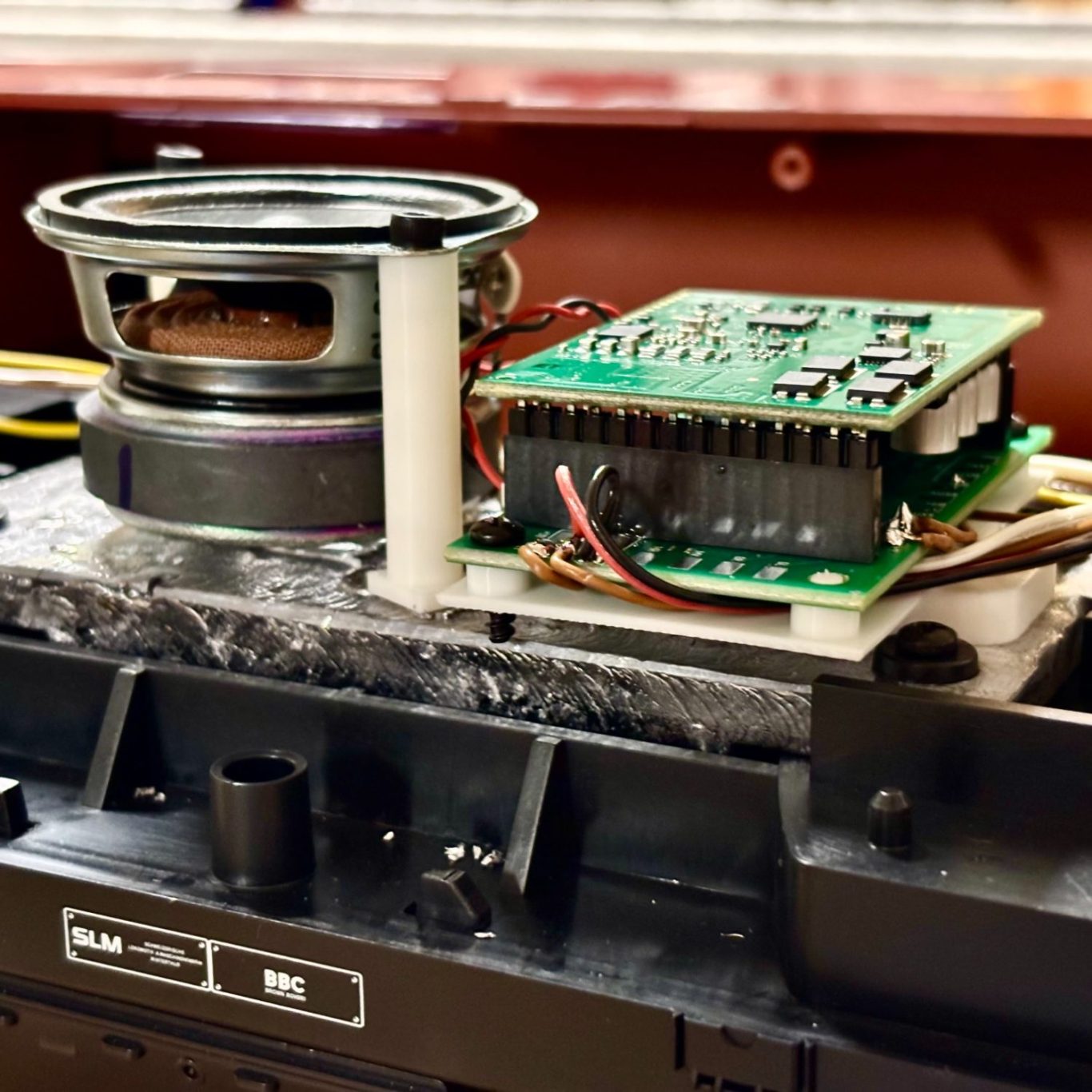 Digitalisierung Modellbahn Lok Mann arbeitet an einer Modelleisenbahn in einem Werkstattumfeld mit Werkzeug.